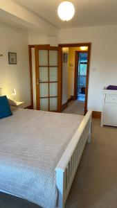 Beautiful Bexhill Cottage with garden 3 mins walk to beach في بيكسهيل: غرفة نوم بسرير كبير في غرفة