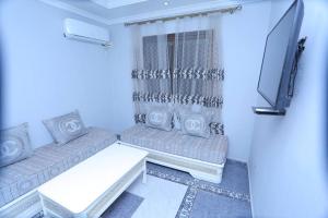 sala de estar con 2 sofás y TV de pantalla plana en Appartement meublé Oran en Orán