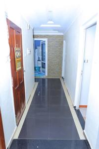 einen Flur mit einem langen Korridor mit einer Tür und einem Zimmer in der Unterkunft Appartement meublé Oran in Oran