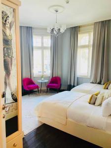 um quarto grande com 2 camas e cadeiras cor-de-rosa em 29A Guesthouse em Plovdiv