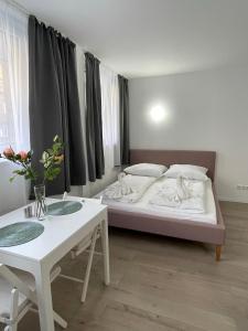 a bedroom with a bed and a table with flowers on it at Schöne Moderne Wohnung am Ring Nr.1 in Cologne