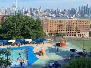 a large swimming pool with a city in the background at 1 COZY APt IN WEST NY, NEW JERSEY, at 2 bloks from bus stop-15 minutes 2NY 7MINUTES VIA NYWATERWAY FERRY-BETTER CAN'T BE!! in West New York