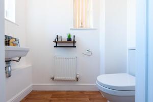 a white bathroom with a toilet and a sink at Parking - Spacious - Smart TV - Self CheckIn - Garden - King in Derby