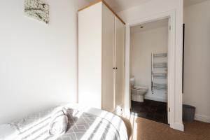 a bedroom with a bed and a bathroom with a toilet at Parking - Spacious - Smart TV - Self CheckIn - Garden - King in Derby +25 photos