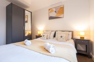a bedroom with a large white bed with towels on it at Parking - Spacious - Smart TV - Self CheckIn - Garden - King in Derby