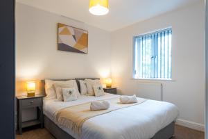 a bedroom with a large white bed with two lamps at Parking - Spacious - Smart TV - Self CheckIn - Garden - King in Derby