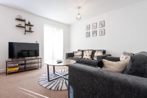 a living room with two couches and a tv at A beautiful serviced home with parking and garden, Derby in Derby
