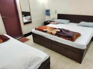 two twin beds in a room with a mirror at Avadh vihara Beds & Breakfast in Varanasi