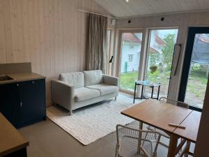 a living room with a couch and a table at Mysigt attefallshus med närhet till stad och hav in Västra Frölunda