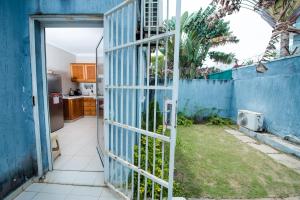 an open door to a kitchen with a blue fence at Duplex moderne avec vue exceptionnelle sur la mer in Pointe-Noire
