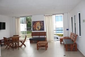 sala de estar con sillas, mesas y ventanas en Villas del Guali - Piscina Privada, en Santa Fe de Antioquia