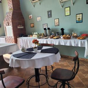 a room with several tables with white table cloths at Pousada Recanto João de Barro in Cunha +66 photos
