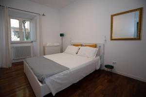 a bedroom with a white bed and a mirror at Domus Cordara - Splendido appartamento nel verde in Rome