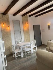 a dining room with a white table and chairs at Casa Puerta sierra de Cádiz in Arcos de la Frontera