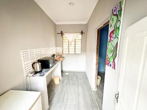 a small kitchen with a sink and a microwave at Mama's House in Kibweni