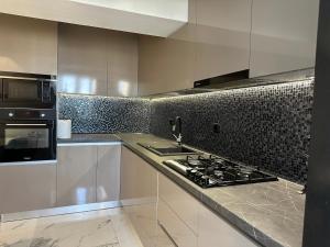 uma cozinha com um fogão e um micro-ondas em Top View Unirii Penthouse em Bucareste
