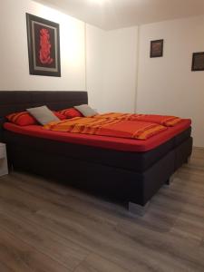 a bed in a bedroom with a red mattress at Charlottenhöhe Apartment in Rottweil