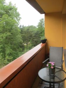 a balcony with a table and chairs and a window at Liepaja Pine Apartment in Liepāja