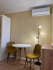 een tafel en 2 stoelen in een kamer bij Quiet flat with balcony, free parking included in Cluj-Napoca