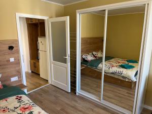 een slaapkamer met een bed en een kast met een spiegel bij Quiet flat with balcony, free parking included in Cluj-Napoca