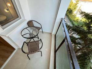een balkon met 2 stoelen en een raam bij Quiet flat with balcony, free parking included in Cluj-Napoca