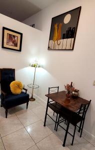 ein Wohnzimmer mit einem Tisch und einem Stuhl in der Unterkunft Villa Las Palmeras South Miami in Miami