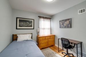 1 dormitorio con cama, escritorio y silla en Pet-Friendly Falls Church Home with Fenced Backyard!, en Falls Church