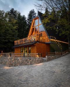 ein Holzhaus mit einer großen Terrasse und einer Treppe in der Unterkunft forest angel rg in Ravna Gora