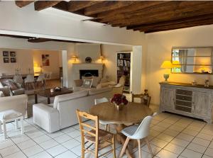 a living room with a couch and a table at Chambres à la maison Hermitage in Aincourt