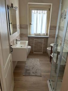 bagno con lavandino, servizi igienici e finestra di Casa Nonna Ada a Cisterna dʼAsti