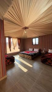a large room with two beds and a ceiling at Wadi Rum Star Camp in Wadi Rum