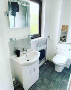 a bathroom with a sink and a toilet at Coastal Corner in Porthcawl