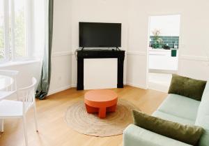a living room with a couch and a table with a television at Le TerraCotta ⸱ Stationnement gratuit ⸱ Fibre in Déols