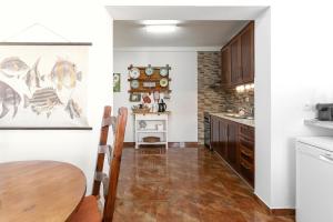 a kitchen with white walls and a table in a room at Matias Terrace House in Lourinhã