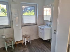 a small bathroom with a sink and two windows at Haus Swanhild in Fockbek +46 photos