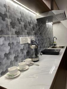 eine Küche mit drei Tassen und Untertassen auf einer Theke in der Unterkunft Spacious High Rise Studio Apartment - By MESA in Nagoya
