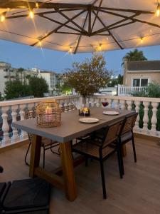 een tafel en stoelen op een balkon met een parasol bij Casa Narú Albir, duplex appartement met ruim terras en buitenkeuken in Albir