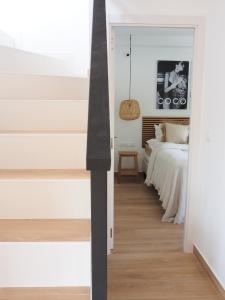 - une chambre avec des murs blancs et un lit dans l'établissement Casa Narú Albir, duplex appartement met ruim terras en buitenkeuken, à Albir