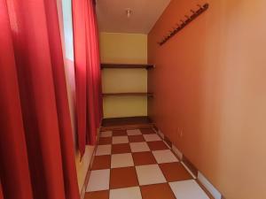 un corridoio con tende rosse e pavimento a scacchiera di Sunrise Guest House a Huaraz