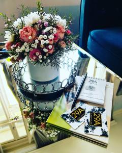un jarrón con flores sobre una mesa de cristal en 29A Guesthouse, en Plovdiv