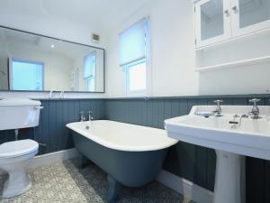 a bathroom with two sinks and a tub and a toilet at Dartmouth Cottage - River and Sea Views with Parking Permit in Dartmouth