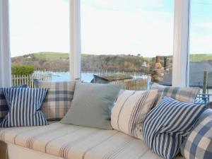 a couch sitting on a porch with pillows on it at Dartmouth Cottage - River and Sea Views with Parking Permit in Dartmouth