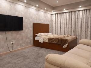 1 dormitorio con 1 cama y TV de pantalla plana en LUXURY HOTEL APARTMENT RENTAL en Alexandría