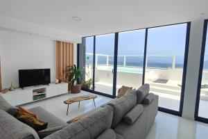 uma sala de estar com um sofá e uma televisão em Luxury Penthouse with Private Pool, Ocean, City & Mountain view 6 Pers 2 BR em Lazareto