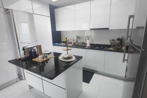 a kitchen with white cabinets and a black counter top at Luxury Penthouse with Private Pool, Ocean, City & Mountain view 6 Pers 2 BR in Lazareto