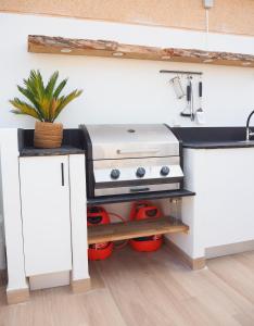 Il comprend une cuisine équipée d'une cuisinière et d'un évier. dans l'établissement Casa Narú Albir, duplex appartement met ruim terras en buitenkeuken, à Albir