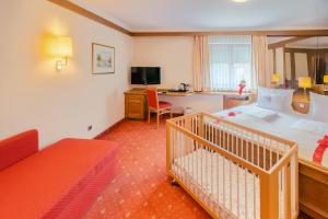 a hotel room with a crib in a bedroom at Hotel am Schlosspark Zum Kurfürst in Oberschleißheim +57 photos