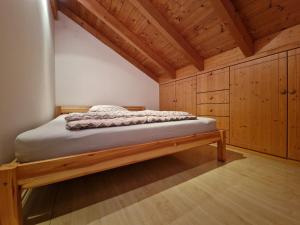 a bed in a room with wooden cabinets at Ruhige Lage schnelles Internet 100 Mbits Netflix LG TV 4K 55" Bosch Waschmaschinen und Wäschetrockner in Waging am See