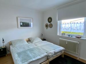 a white bedroom with a bed and a window at Die 2eitwohnung in Hochheim am Main