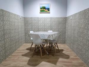 a dining room with a white table and chairs at YK Homestay in Kulai